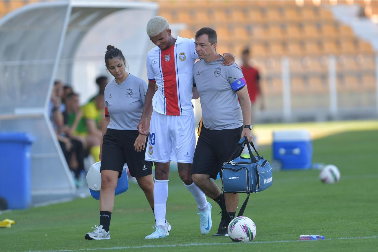 Dr. Rodrigo Oliveira amparando atleta na saída do campo